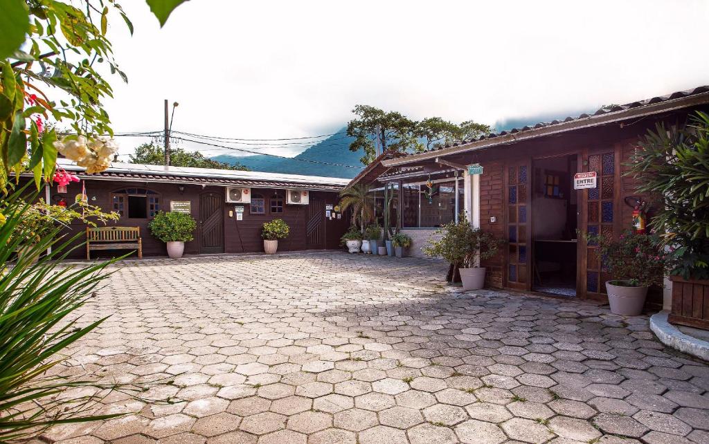 a cobblestone driveway in front of a building at Pousada Novo Encanto Maresias in Maresias