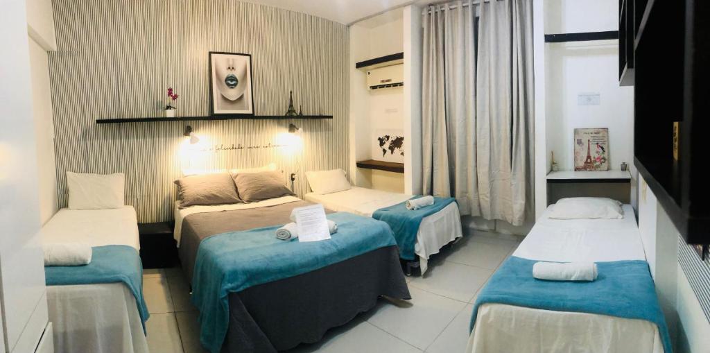 a hotel room with three beds in a room at Aconchego Carioca Ipanema Copacabana Rua da praia in Rio de Janeiro