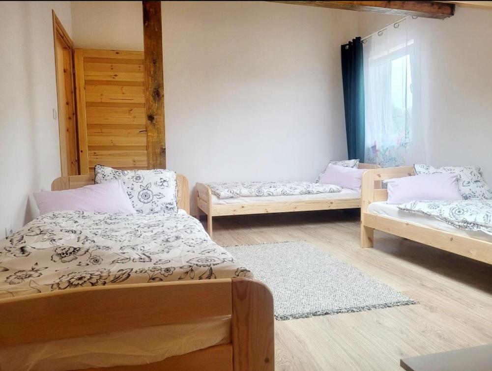 um quarto com três camas e uma janela em Apartamenty i pokoje gościnne pod lasem em Nadarzyn