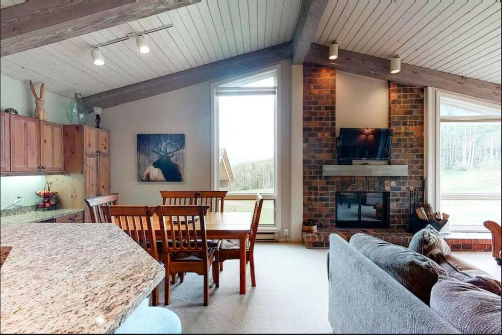 a living room with a table and a fireplace at Enclave 305, Snowmass Ski-In/Ski-Out Condo w/Shared Pool/Hot Tub in Snowmass Village