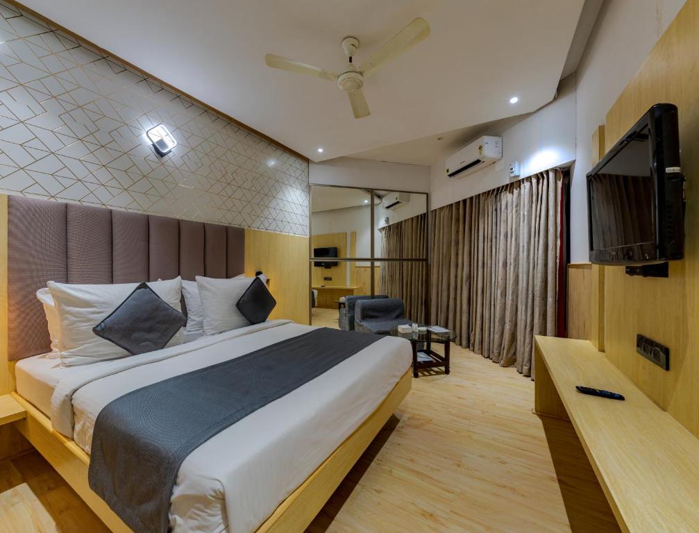 a hotel room with a bed and a television at Hotel Surya Executive 3 Star Hotel in Solapur