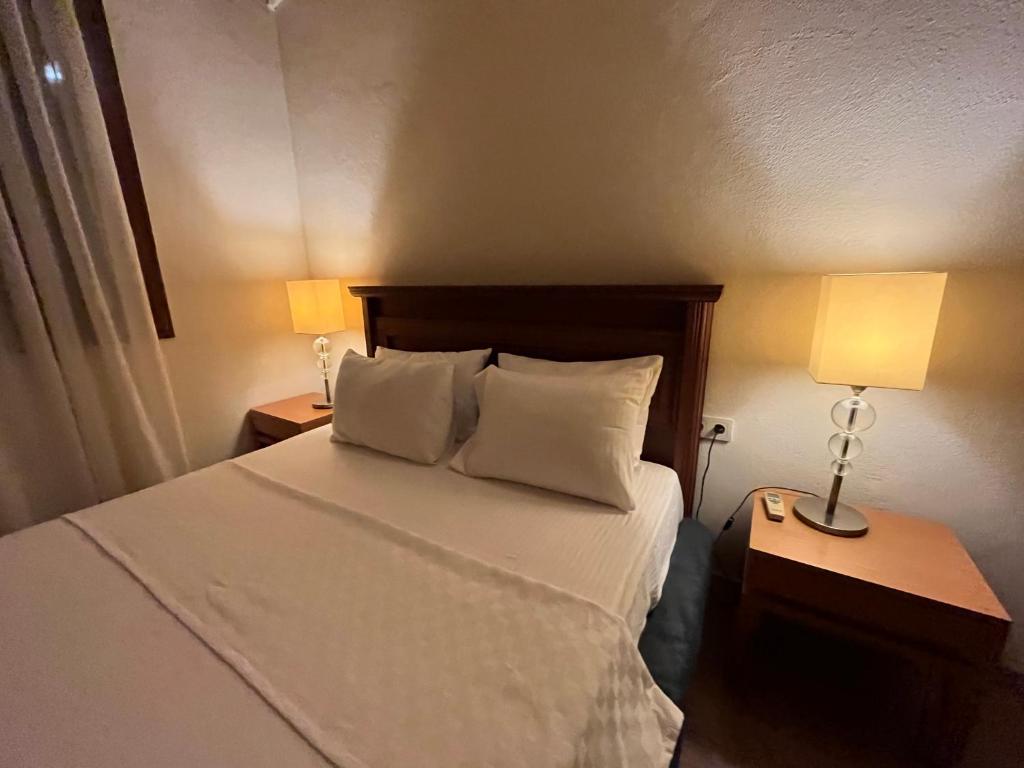Cama en habitación de hotel con 2 lámparas y cama sidx sidx sidx sidx sidx sidx en Kibala Hotel, en Cıralı