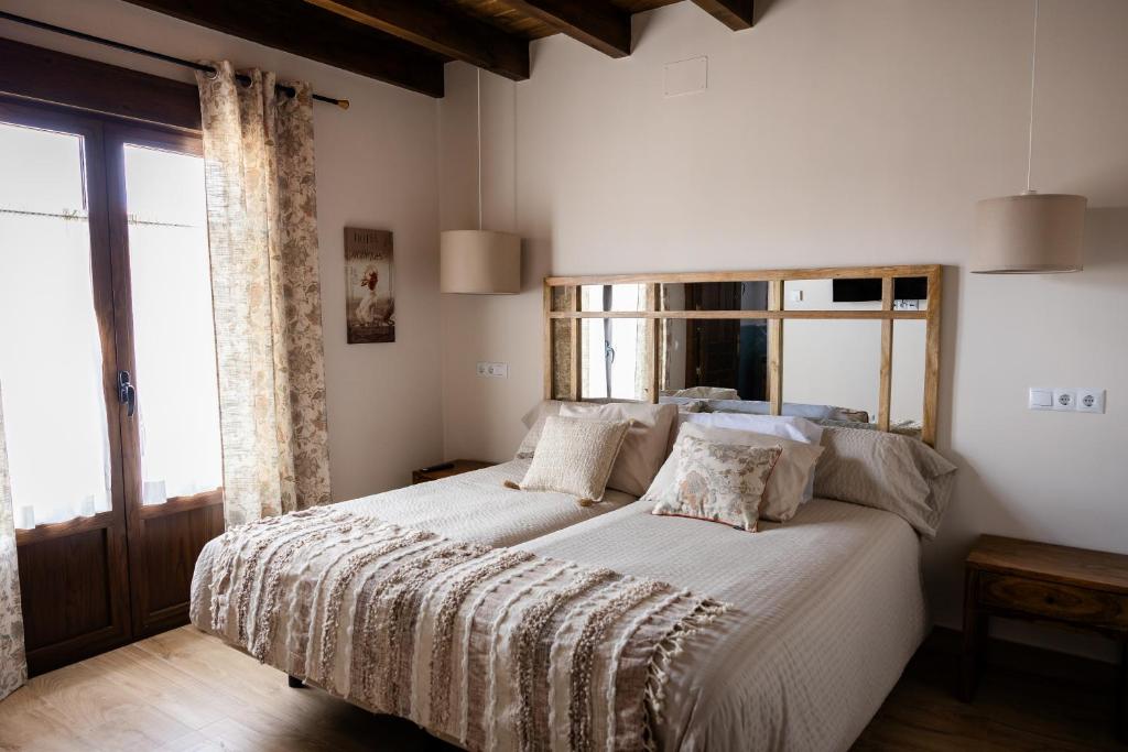 ein Schlafzimmer mit einem großen Bett und einem großen Fenster in der Unterkunft Casa Rural Alcolea del Pinar in Alcolea del Pinar