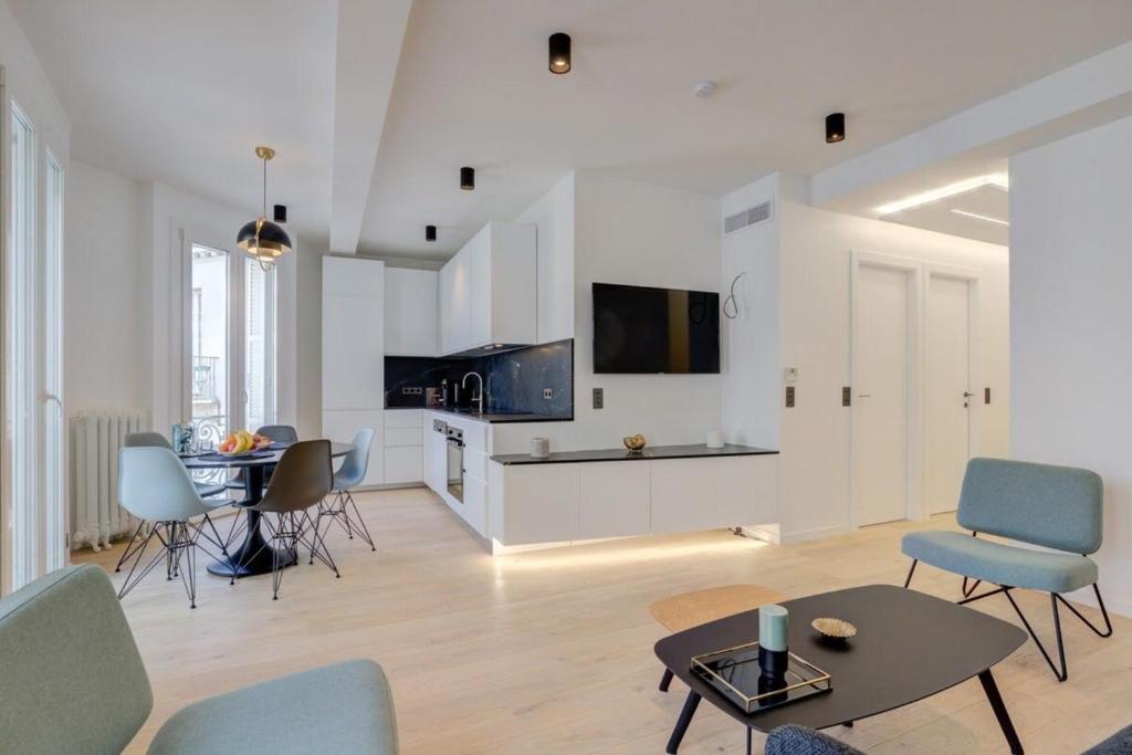 uma sala de estar branca com uma mesa e cadeiras em Magnificent renovated 4-room apartment - Croisette Carre d'or em Cannes