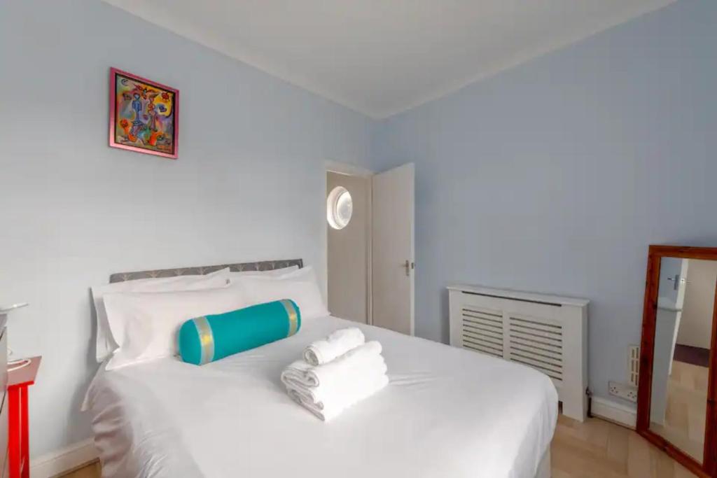 a bedroom with a white bed with towels on it at Tasteful & Homely 1BD Flat - Brixton in London