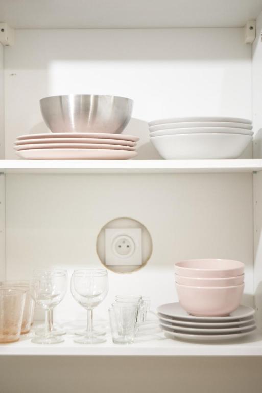 a white shelf with plates and bowls and glasses at Studio cosy Valmy- Vaise-Lyon centre in Lyon