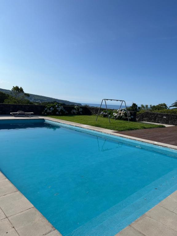 una gran piscina azul con parque infantil en Arrenquinha Guesthouse 2, en Ponta Delgada