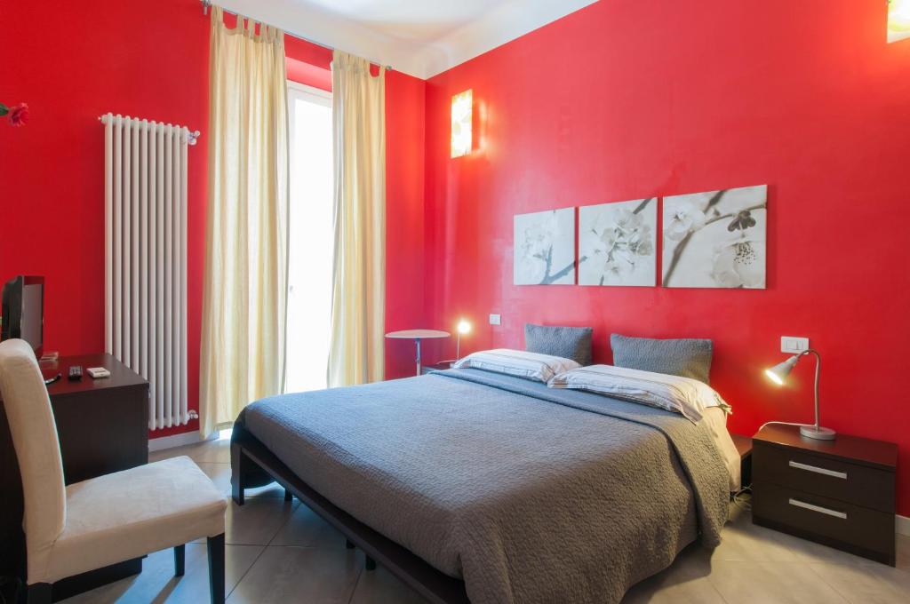 1 dormitorio rojo con 1 cama y 1 silla en Il Cortiletto, en Milán