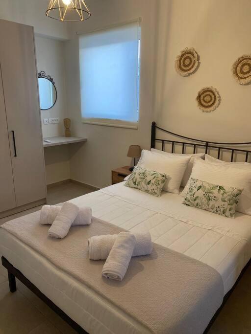 a large white bed with two towels on it at Thalassa Grammeno seaview house in Palaiochora