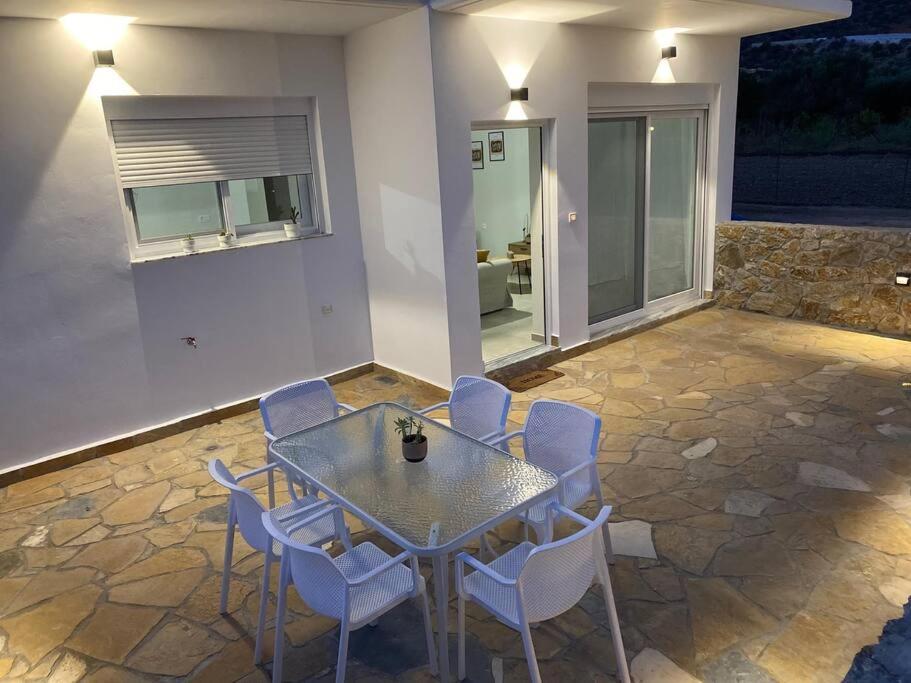a patio with a table and chairs and a window at Thalassa Grammeno seaview house in Palaiochóra