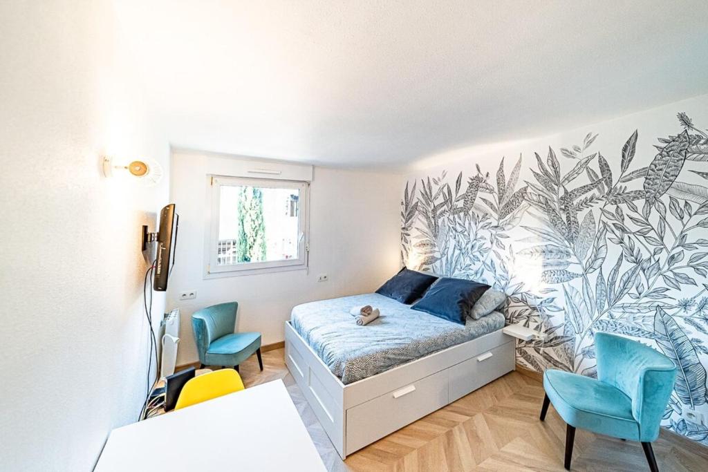 a bedroom with a bed and blue chairs in it at Le petit Million- joli studio rénové-Flachet in Villeurbanne