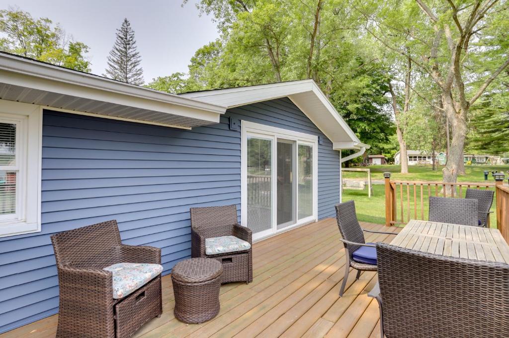a wooden deck with chairs and a table at Lakefront Vacation Rental, 13 Mi to South Haven! in Grand Junction