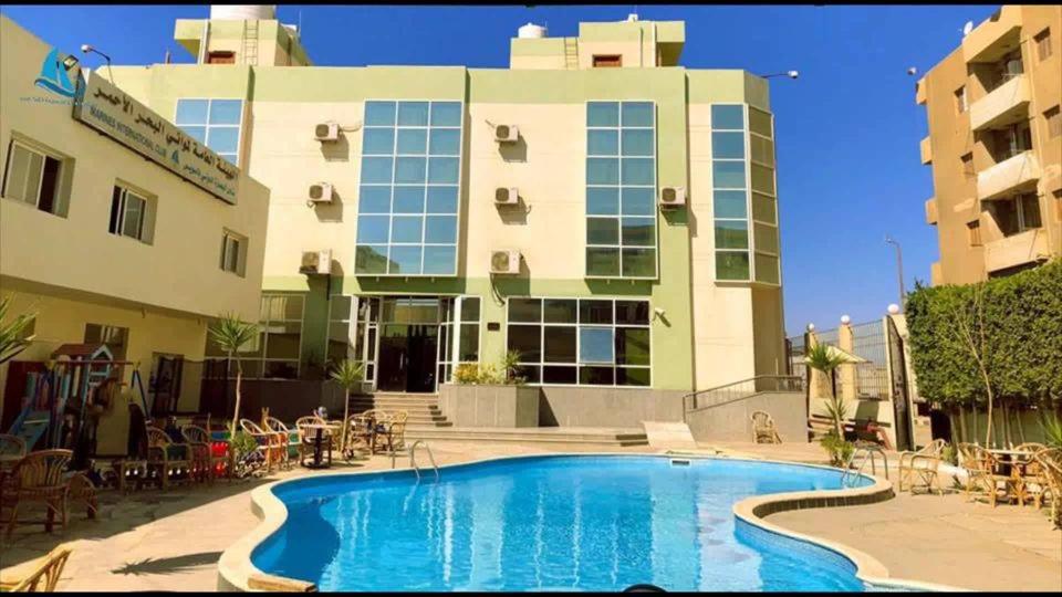 a hotel with a swimming pool in front of a building at نادى البحارة الدولى بالسويس in Suez