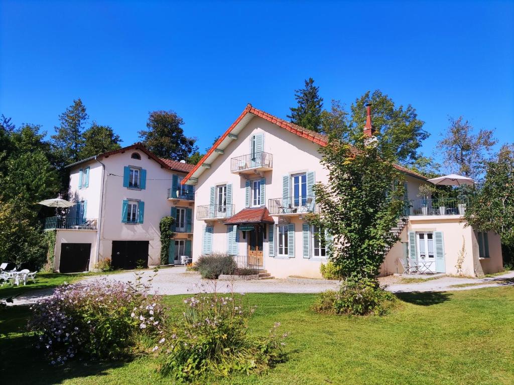 uma grande casa branca com um quintal em Villas du Lac em Clairvaux-les-Lacs