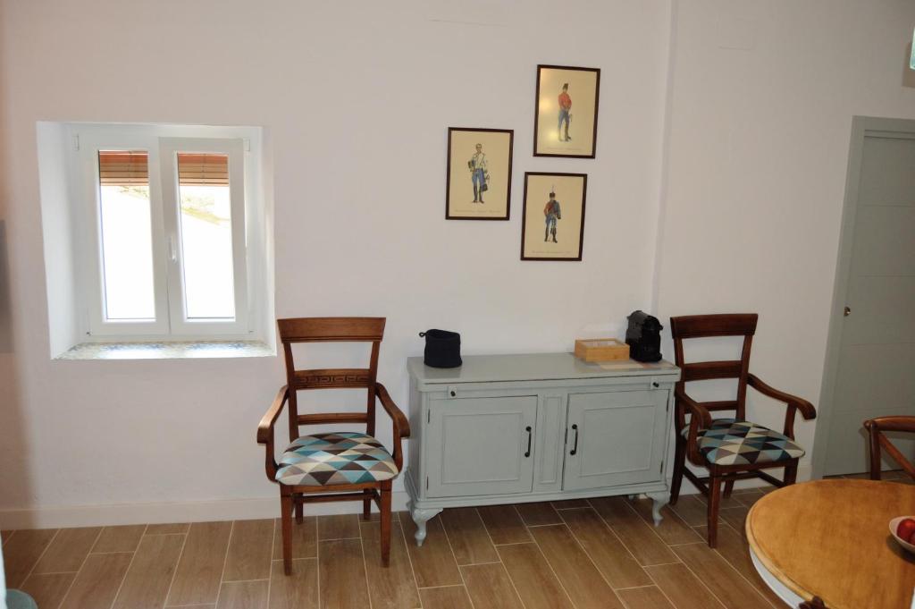 Una habitación con dos sillas y una mesa y una ventana. en Nuestra casa en Vejer, en Vejer de la Frontera
