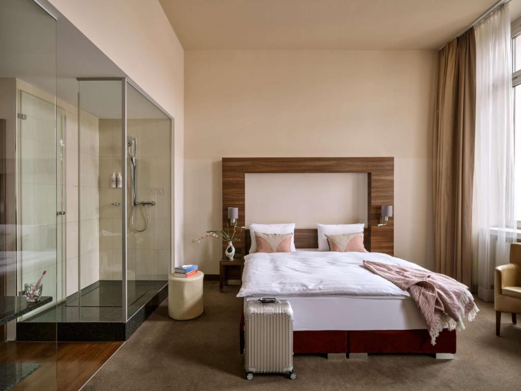 Schlafzimmer mit einem Bett und einer Glasdusche in der Unterkunft Flemings Selection Hotel Wien-City in Wien