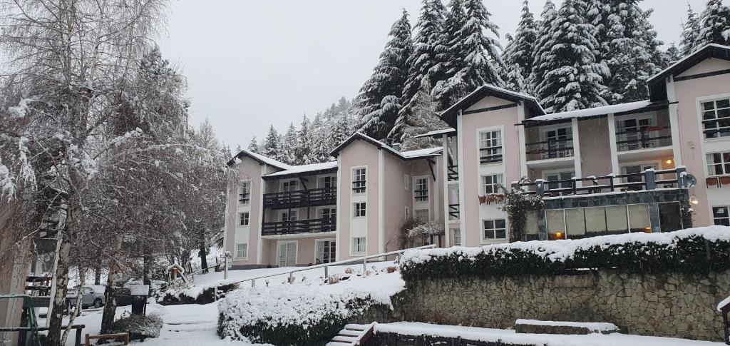 een groep appartementsgebouwen in de sneeuw bij Aldea Andina Hotel&Spa in Bariloche