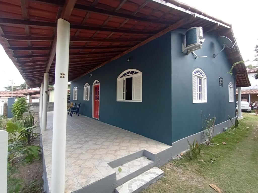 uma casa azul com uma porta vermelha em Casa na beira da Praia Cumuruxatiba em Cumuruxatiba