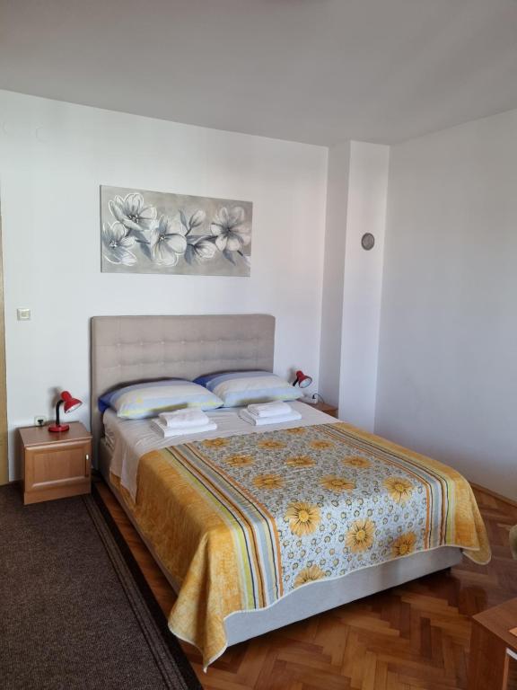 een slaapkamer met een groot bed met 2 kussens bij Apartments Pero in Pula