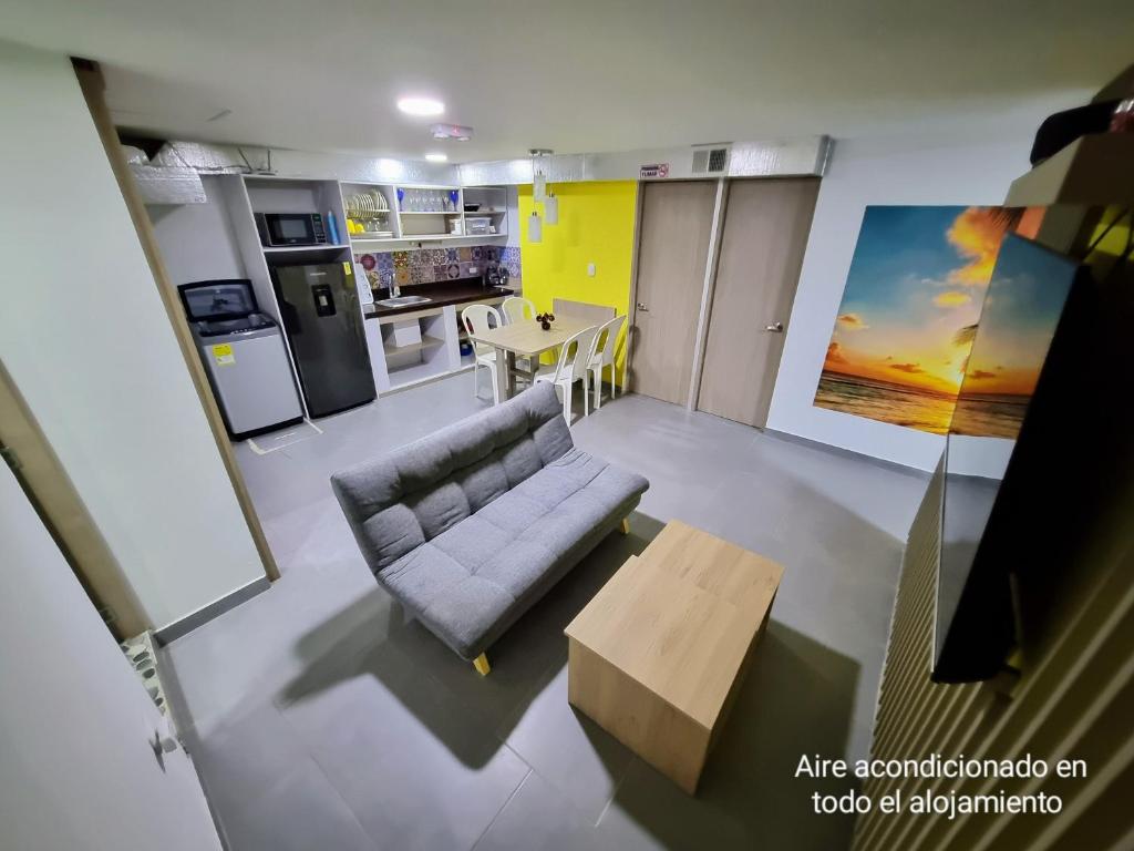 ein Wohnzimmer mit einem Sofa und einem Tisch in der Unterkunft Tranquilo Apartamento Central Cerca a la Playa Puerto Colombia in Puerto Colombia