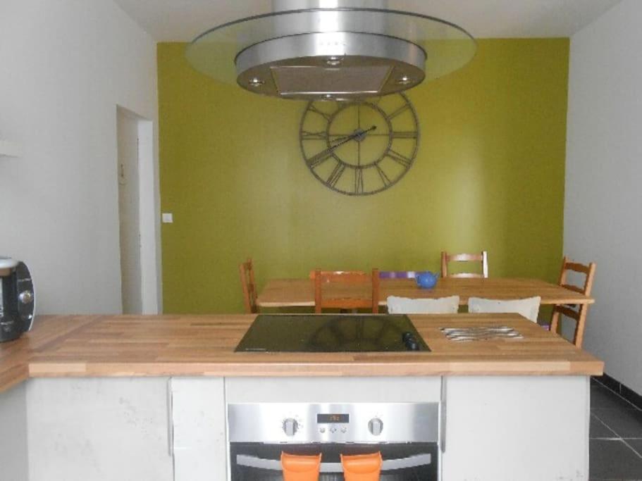 une cuisine avec une table et une horloge au mur dans l'établissement TyChrystel, à Penmarcʼh