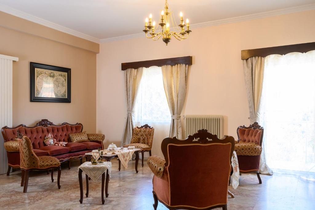 a living room with furniture and a chandelier at Mansion House in Neápolis