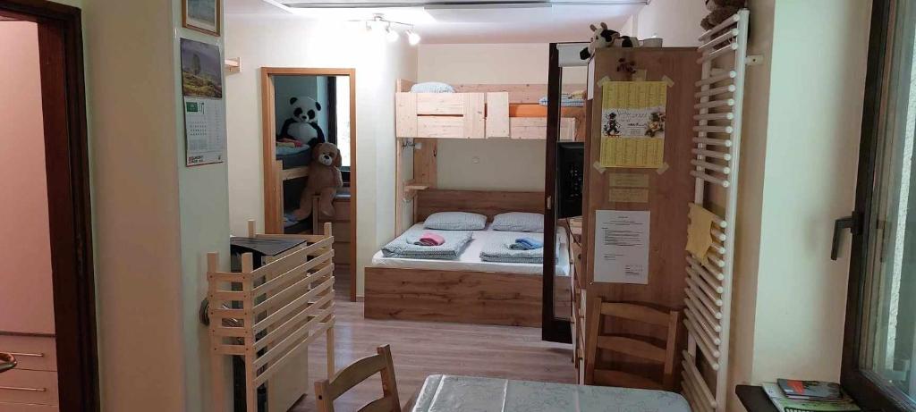 Habitación pequeña con 2 literas y mesa. en Apartma Anja en Zgornje Gorje