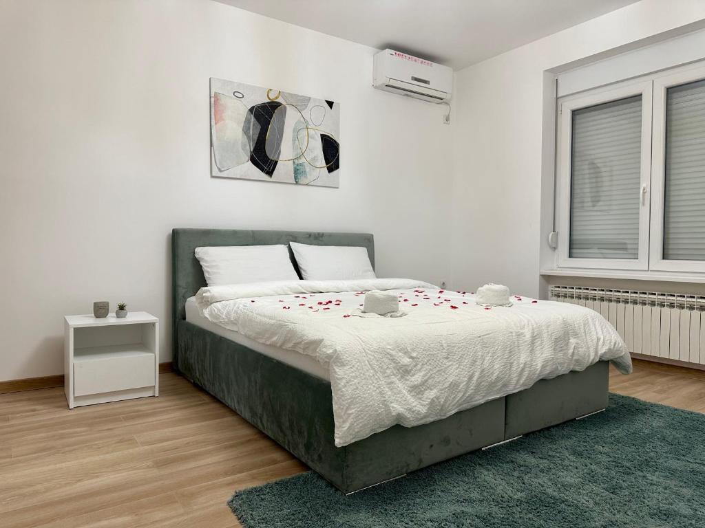 ein Schlafzimmer mit einem Bett mit Rosen darauf in der Unterkunft Apartman Maja in Srbobran
