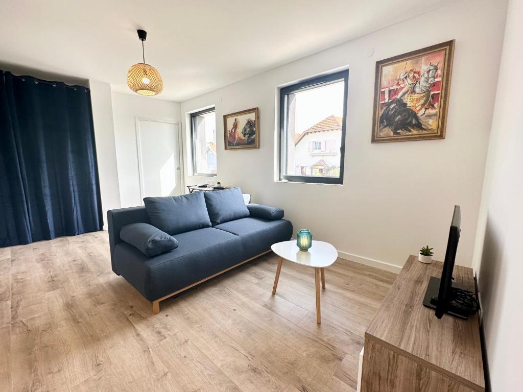 sala de estar con sofá azul y mesa en LES ARÈNES - Lumineux - Centre-Ville en Mont-de-Marsan