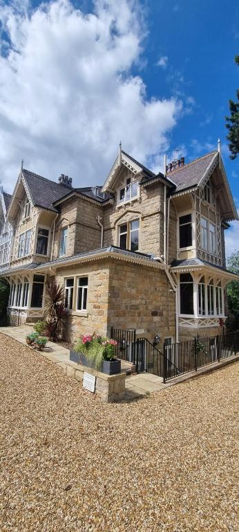 a large brick house with a fence in front of it at The Lawrance Luxury Aparthotel - Harrogate in Harrogate