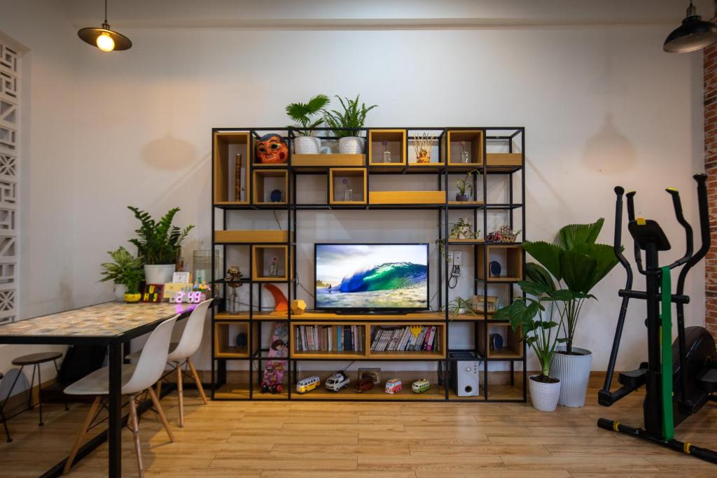 a living room with a television on a book shelf at Vungtau Surf Hostel in Vung Tau