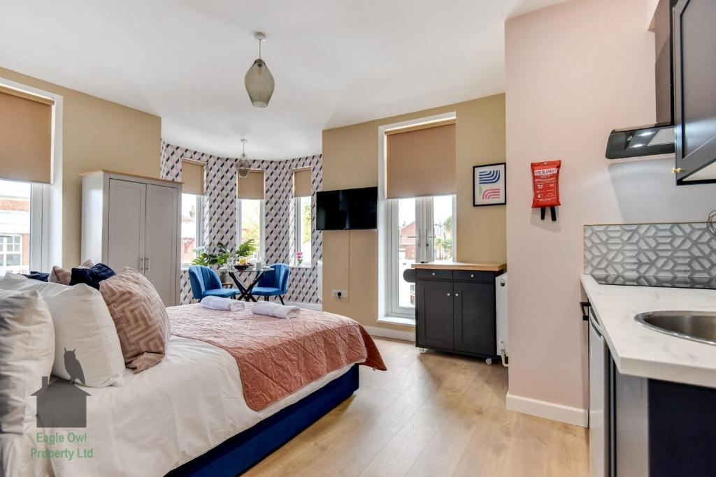 1 dormitorio con 1 cama y lavamanos. en Bright studio with turret and parking by Eagle Owl Property en Worthing