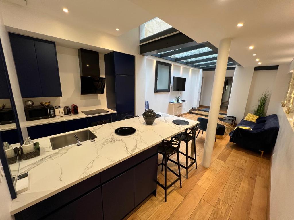 une cuisine avec un grand comptoir et un salon dans l'établissement Appartement 2 chambres climatisé triangle d’or, à Bordeaux
