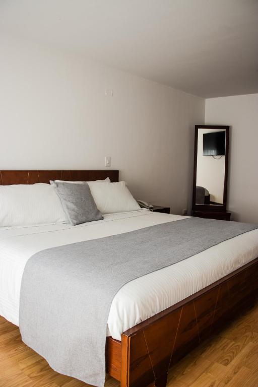 Postel nebo postele na pokoji v ubytování Nogal Suite Hotel Pasto