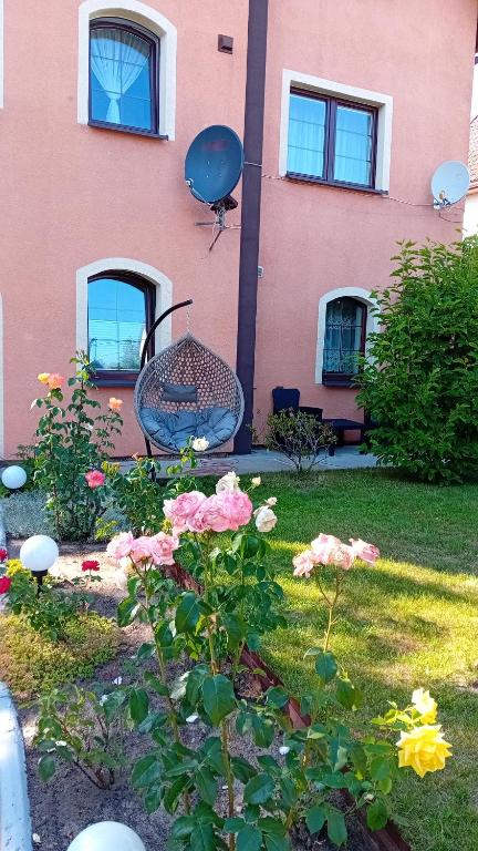 a house with a garden with flowers in front of it at Willa Aleksandra in Żarnowska