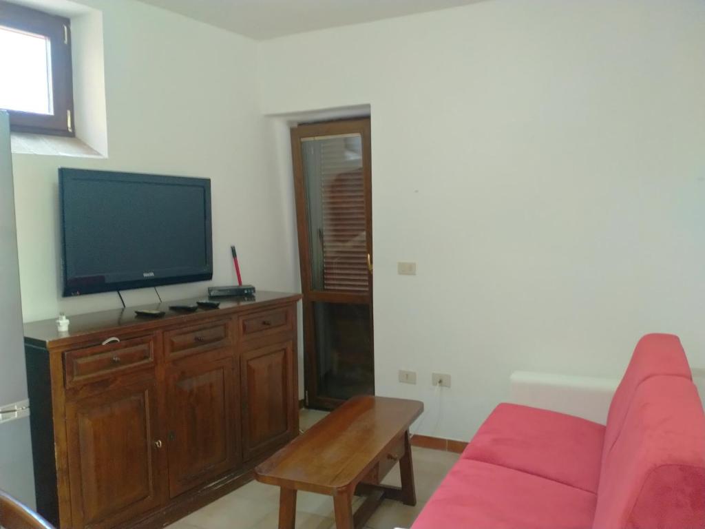 Canino的住宿－Appartamento Indipendente，客厅配有红色沙发和平面电视