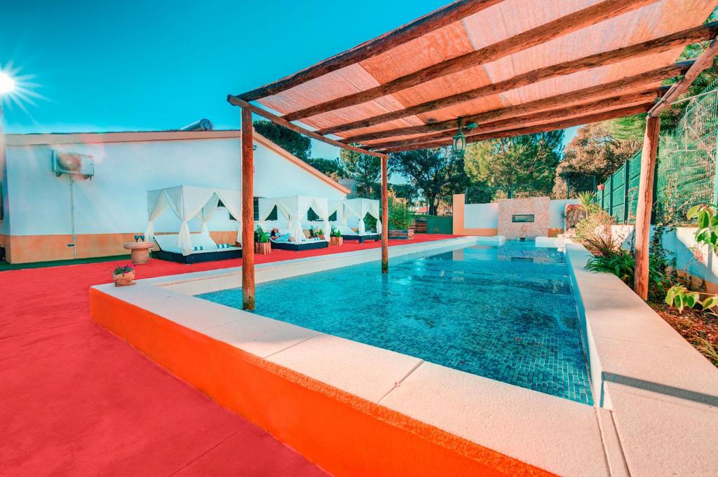 a swimming pool in a house with a red carpet at Herdade da Granja Nova in Montargil