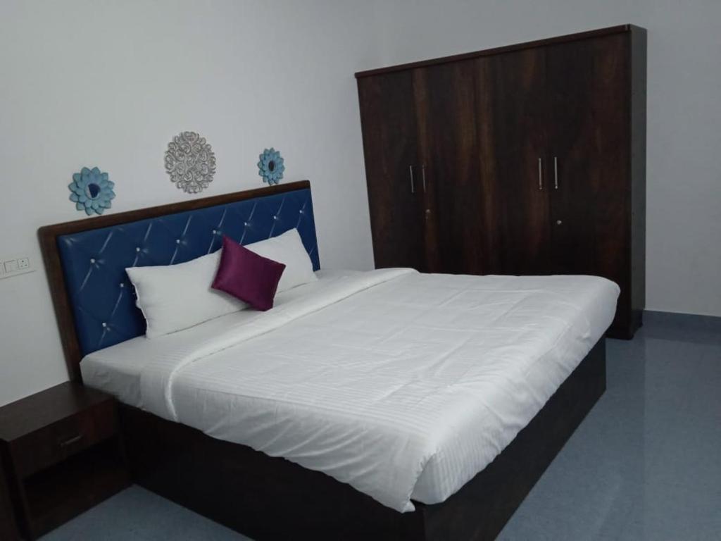 a bedroom with a large bed with a blue headboard at Purple passion in Ranipet