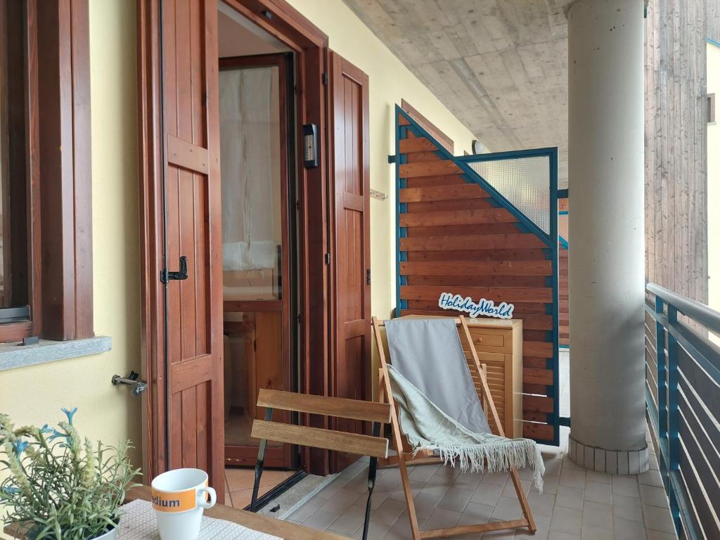 a porch with a chair and an open door at Casa Nevosa by Holiday World in Prato Nevoso