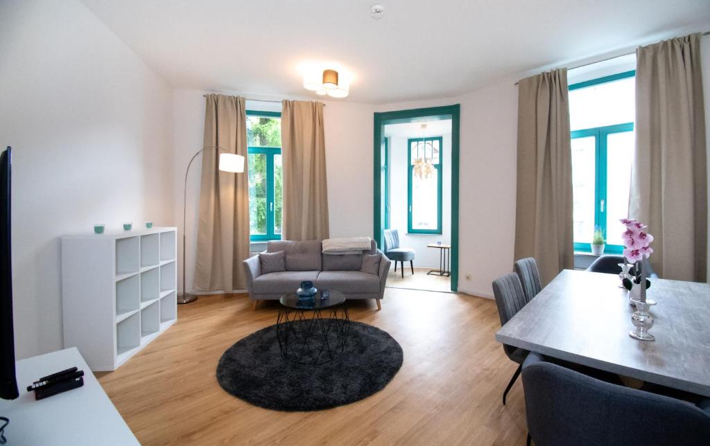 ein Wohnzimmer mit einem Sofa und einem Tisch in der Unterkunft Room&Go: Zentral - Terrasse - Weber Grill in Halle an der Saale
