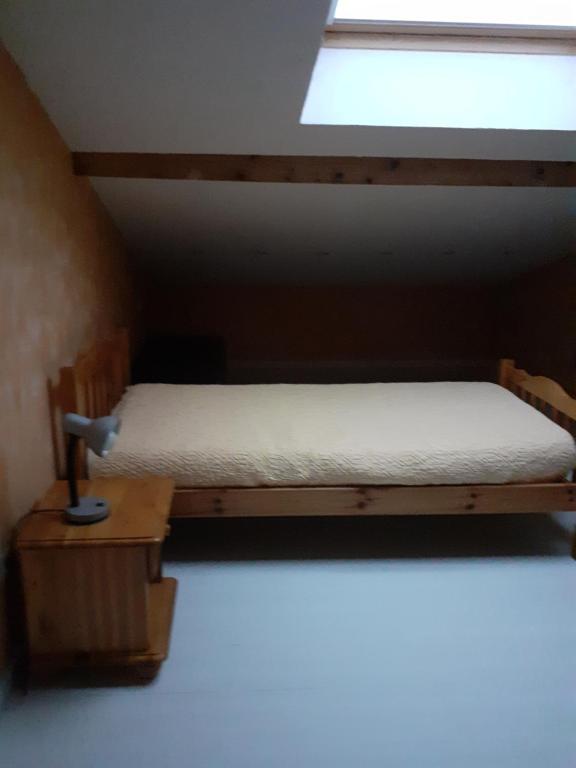 a small bed in a room with a window at Chambre un instant de cocooning 