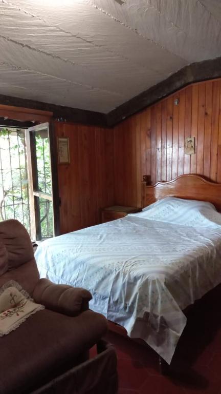 a bedroom with a white bed in a wooden wall at Casa Nina in San Cristóbal de Las Casas