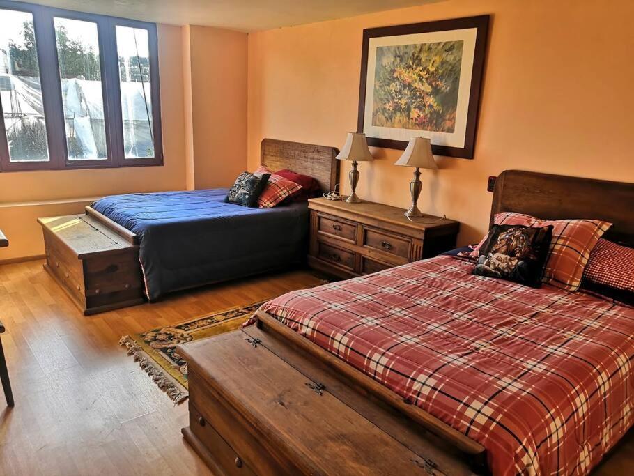 a bedroom with two beds and a dresser and a bed sidx sidx sidx sidx at Hermosa cabaña en Amealco centro in Amealco