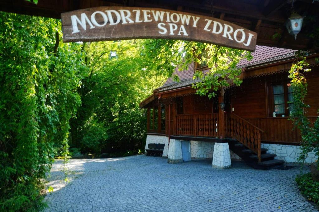的住宿－Modrzewiowy Zdrój，小木屋,上面标有读摩尔本威吉普勒spa的标志