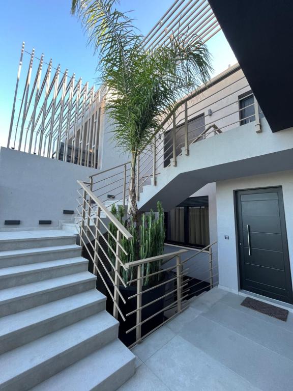 a staircase with a palm tree in front of a building at Grand Kourouta in Kourouta