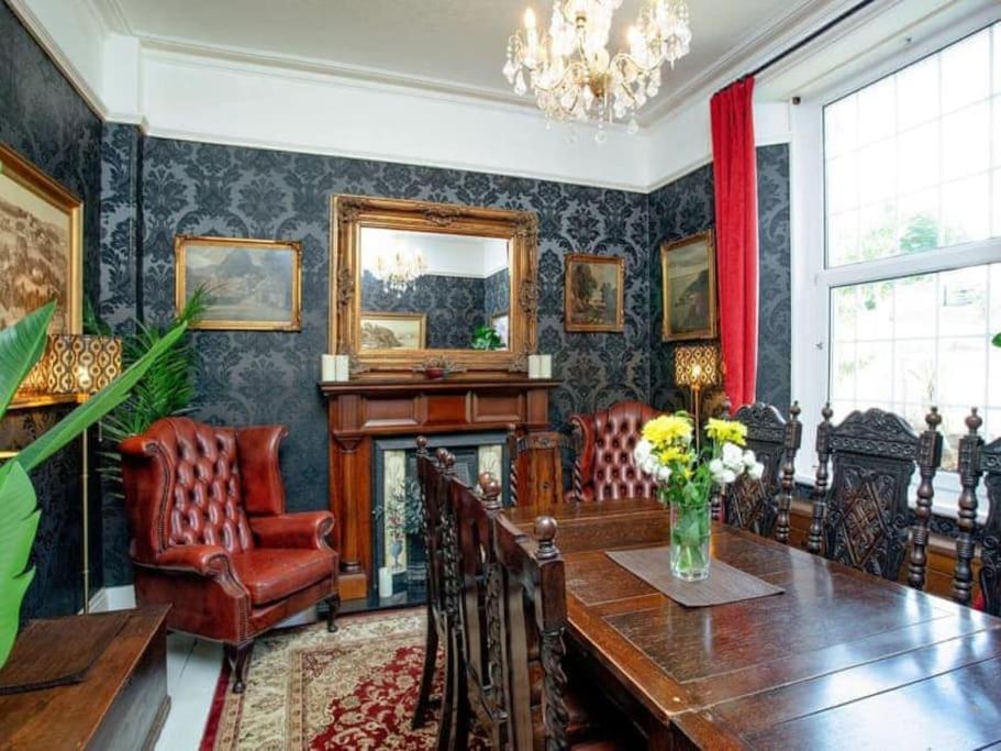 uma sala de jantar com uma mesa e uma lareira em Detached period house in sought after location em Torquay