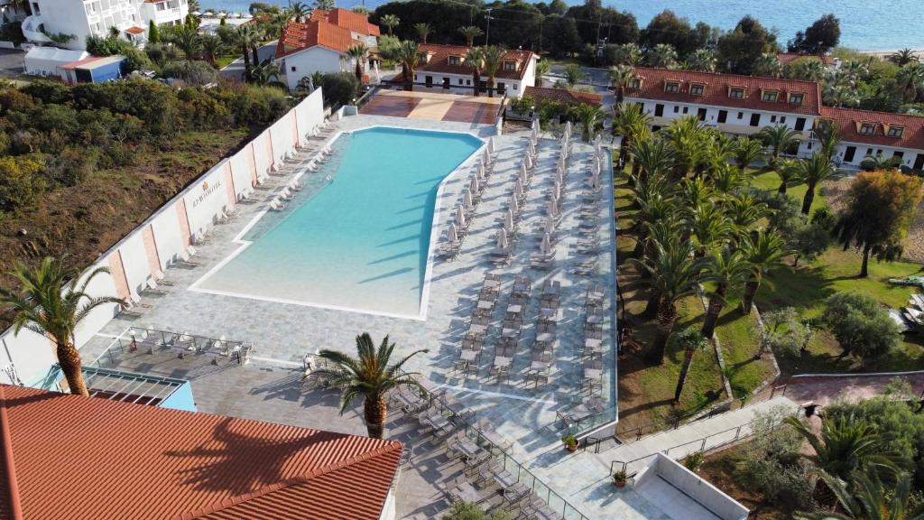 an overhead view of a pool with chairs and palm trees at Aristoteles Holiday Hotel And Spa in Ouranoupoli