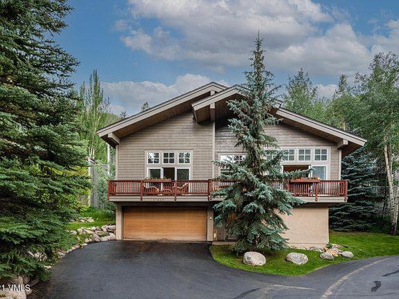 a house with a garage and a tree in front of it at 2782 Kinnikinnick Rd Unit D in Vail