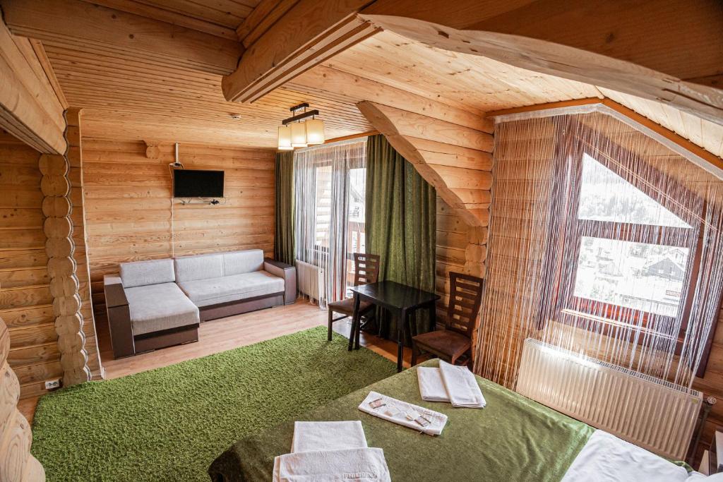 a room with a living room with a couch and a television at Готель Чарда in Bukovel