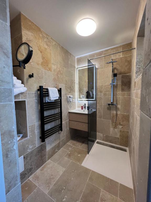 een badkamer met een douche en een wastafel bij Hôtel La Pinède in Soulac-sur-Mer